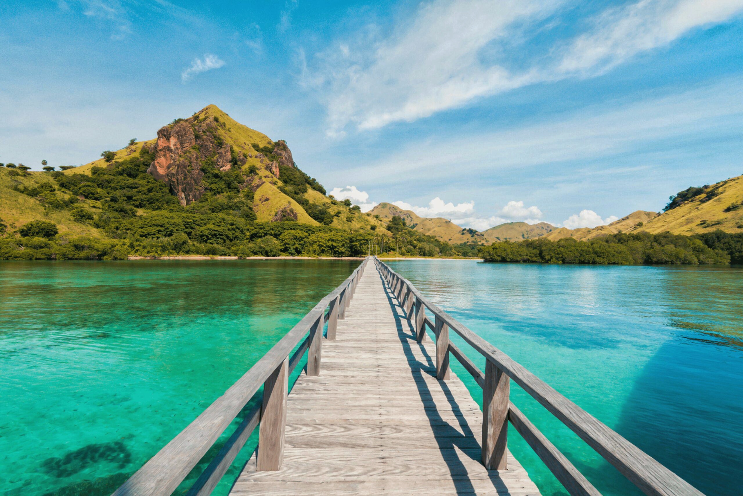 White speedboat cruising through crystal clear turquoise waters with tropical islands in the background